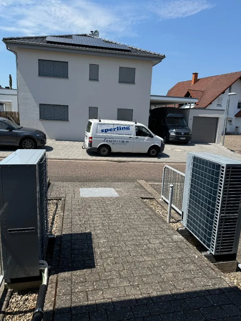 Sperling Servicefahrzeug vor einem Haus mit Wärmepumpen und Solaranlage